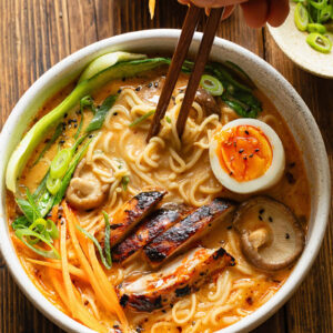 Top down shot of bowl of chicken ramen with chopsticks
