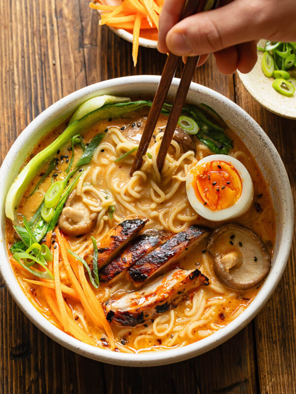 Top down shot of bowl of chicken ramen with chopsticks