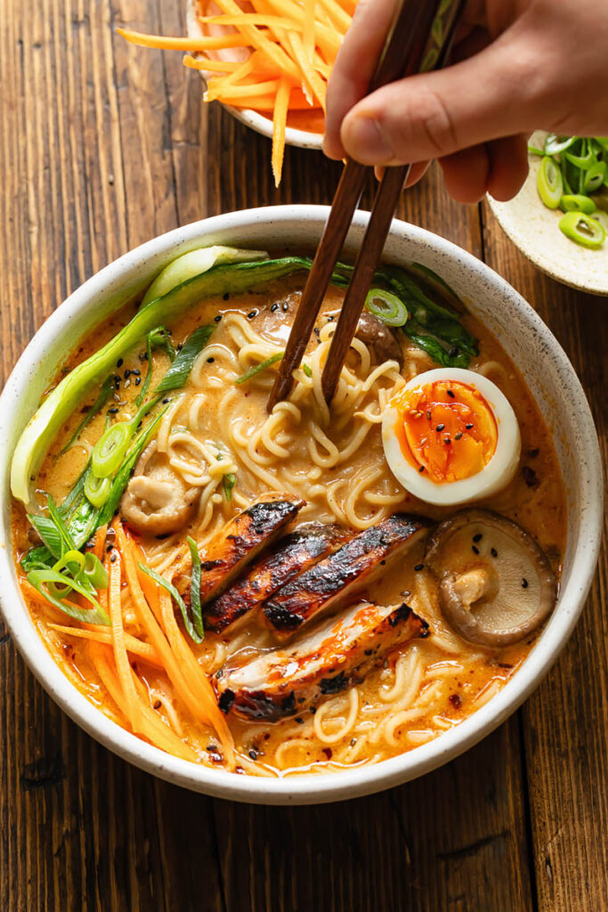 Top down shot of bowl of chicken ramen with chopsticks