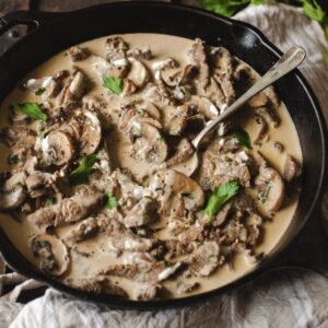 skillet with mushrooms and beef in a creamy sauce