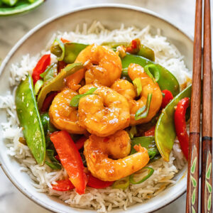 Top down shot of shrimp stir fry in a bowl with chopsticks