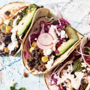 spread of three tacos with shredded vegetable son top