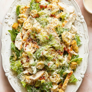 Top down view of chicken Caesar pasta salad on a serving platter