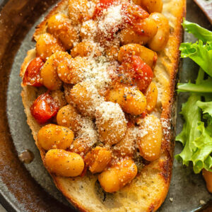 Top down shot of butter beans in tomato sauce on toast
