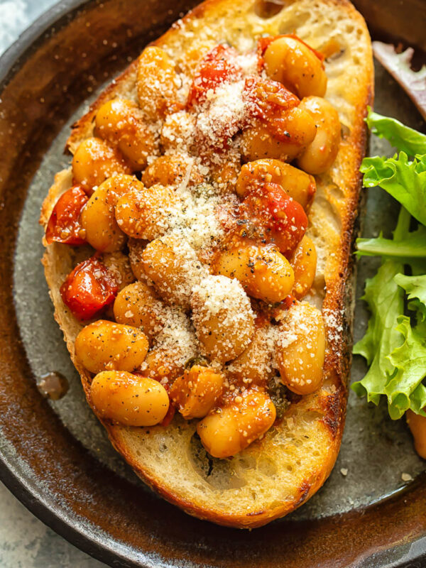 Top down shot of butter beans in tomato sauce on toast
