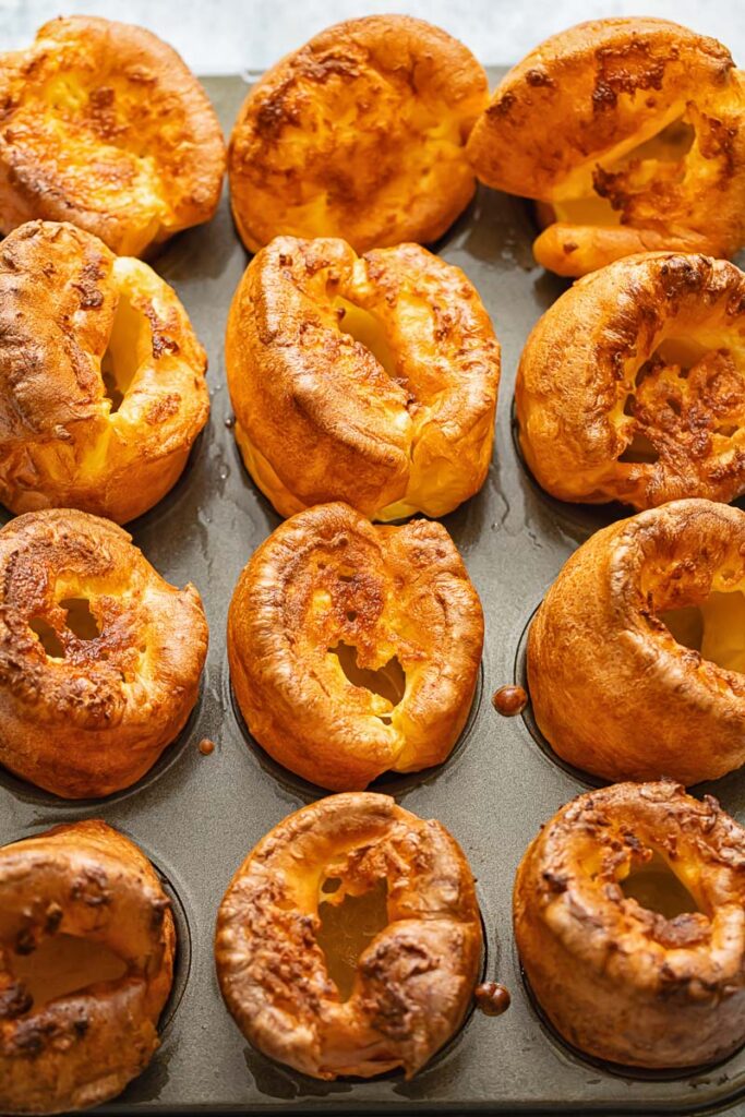 Yorkshire puddings lined up on a baking sheet