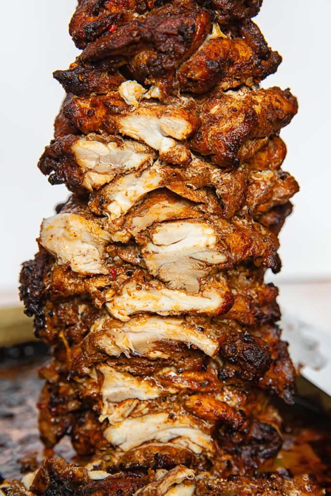 Side of shot of whole chicken shawarma on a meat skewer