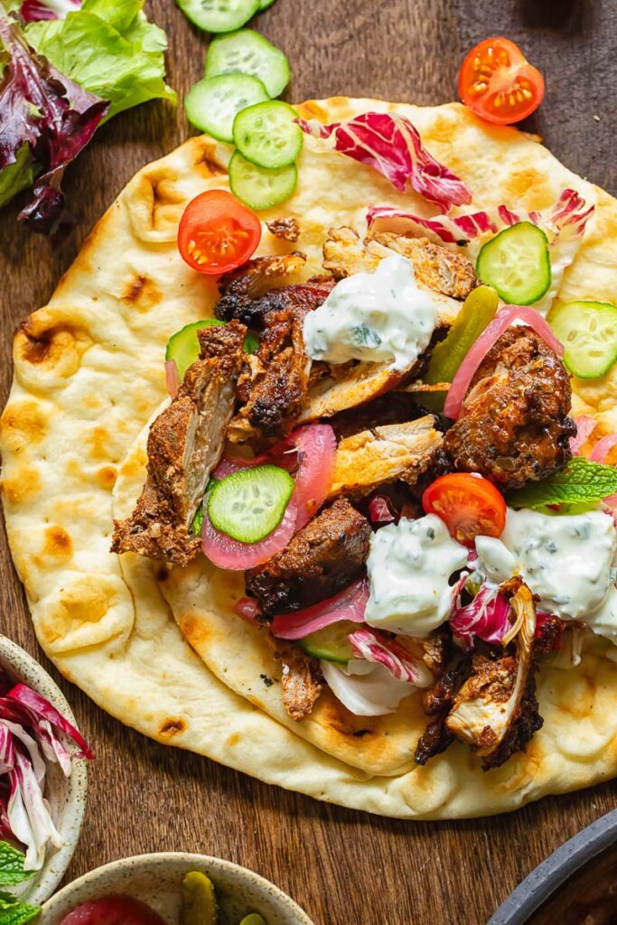 Close up of chicken shawarma on a flatbread with fresh veg