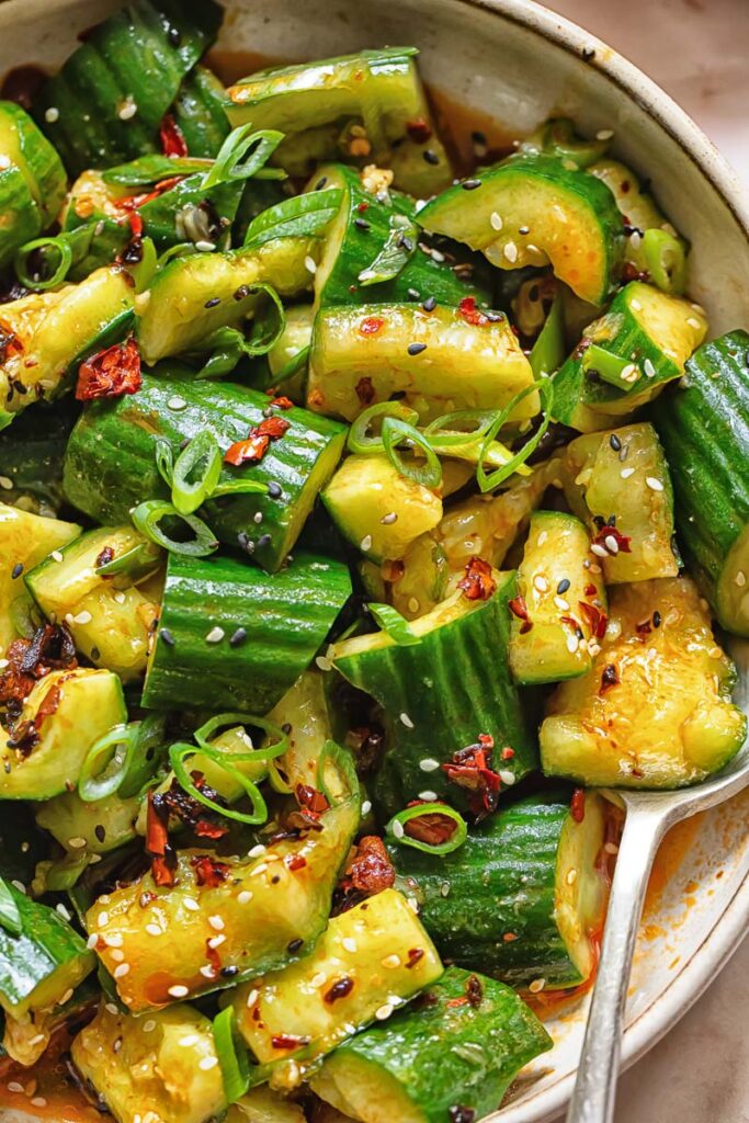 Smashed cucumber salad topped with sesame seeds and green onions