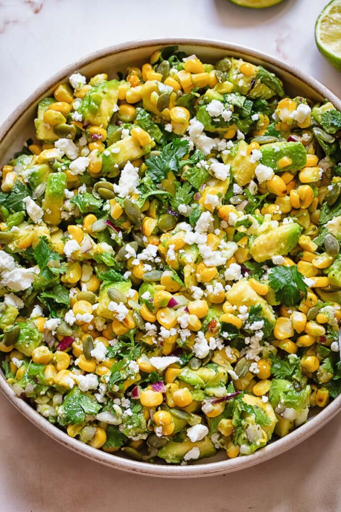 Top down shot of avocado and corn salad in a wide bowl