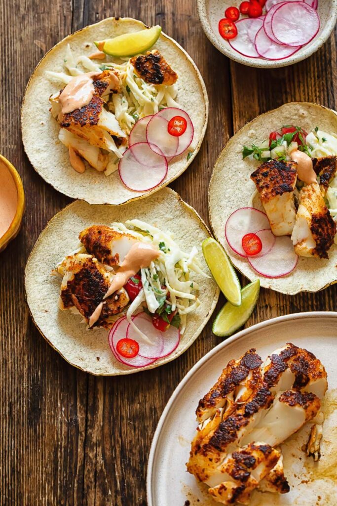 table with several assembled fish tacos