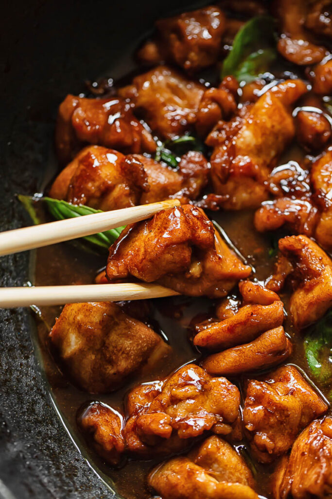 Piece of chicken being picked up with chopsticks 
