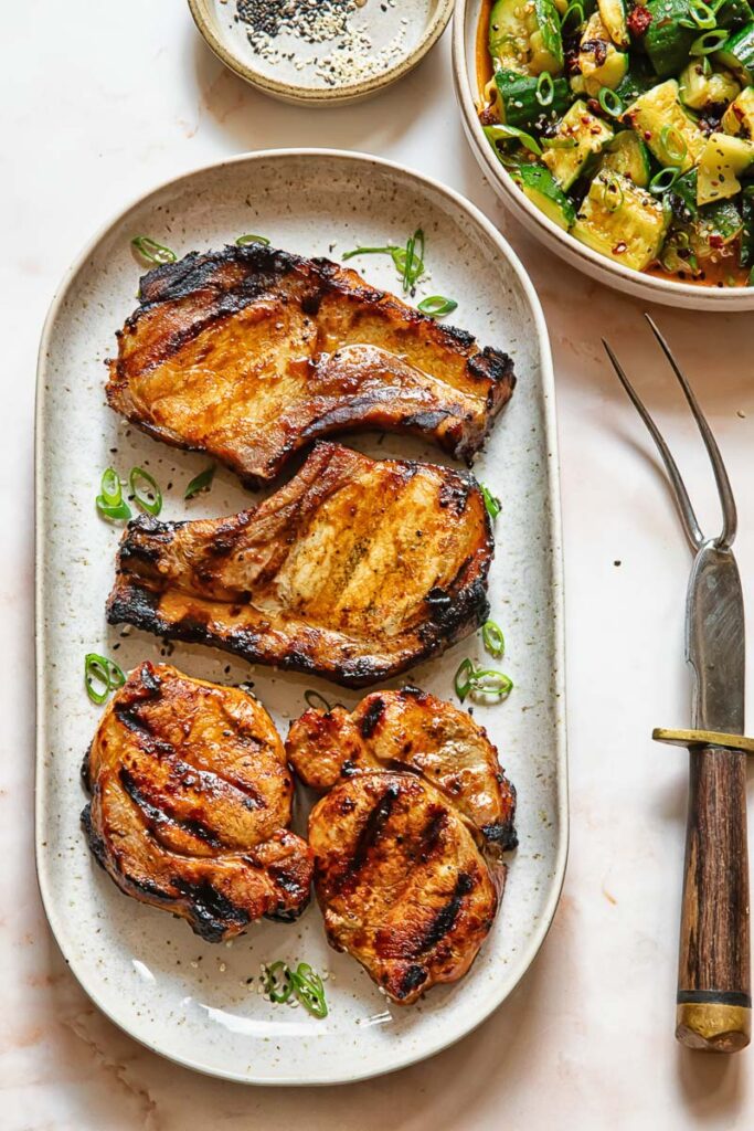 Top down shot of grilled teriyaki pork chops on a serving platter 