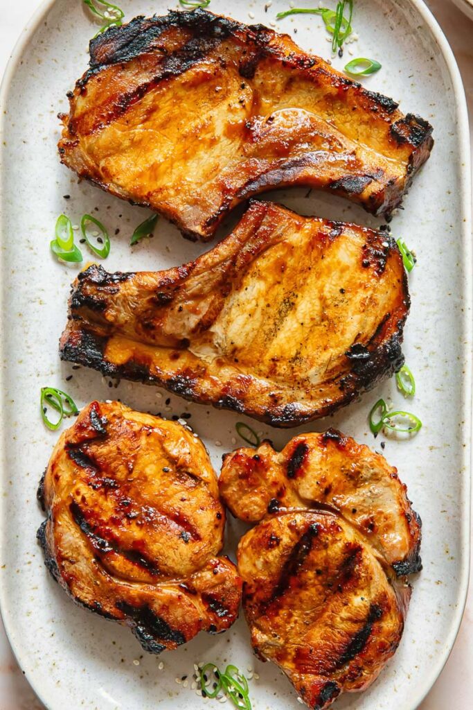 Teriyaki pork chops lined up on a plate