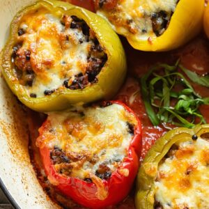 Italian sausage stuffed peppers in tomato sauce in a pan