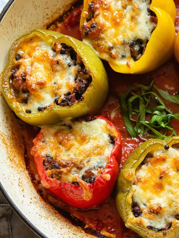 Italian sausage stuffed peppers in tomato sauce in a pan