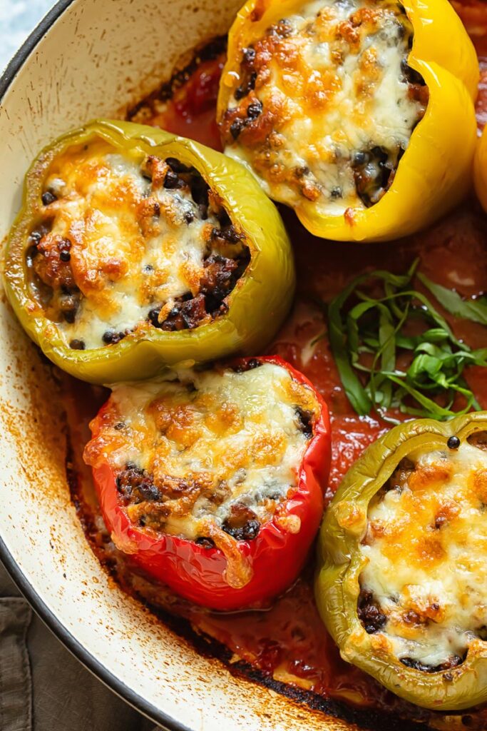 Italian sausage stuffed peppers in tomato sauce in a pan