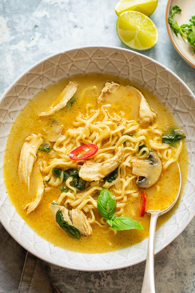 Thai chicken noodle soup in a bowl with a spoon
