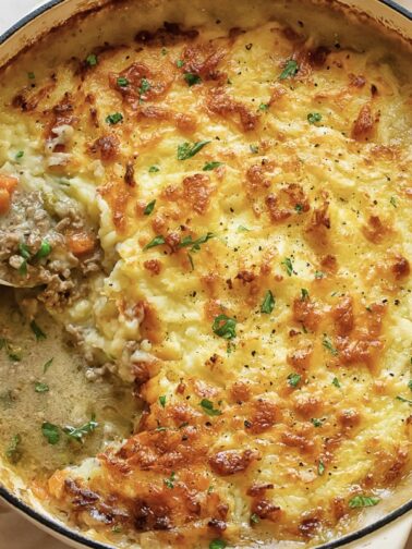 top down view of a shepherd's pie with a spoon taking a serving out.