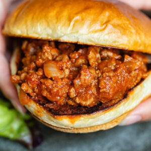 Close up shot of someone holding a sloppy joe