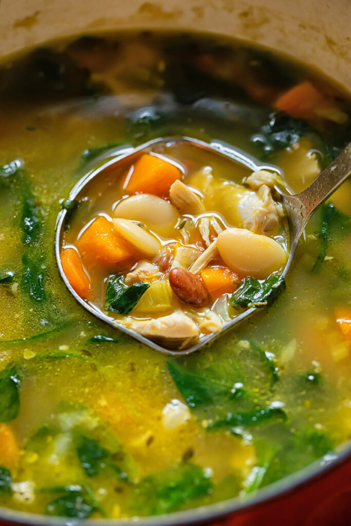 Chicken and bean soup being served from a pot