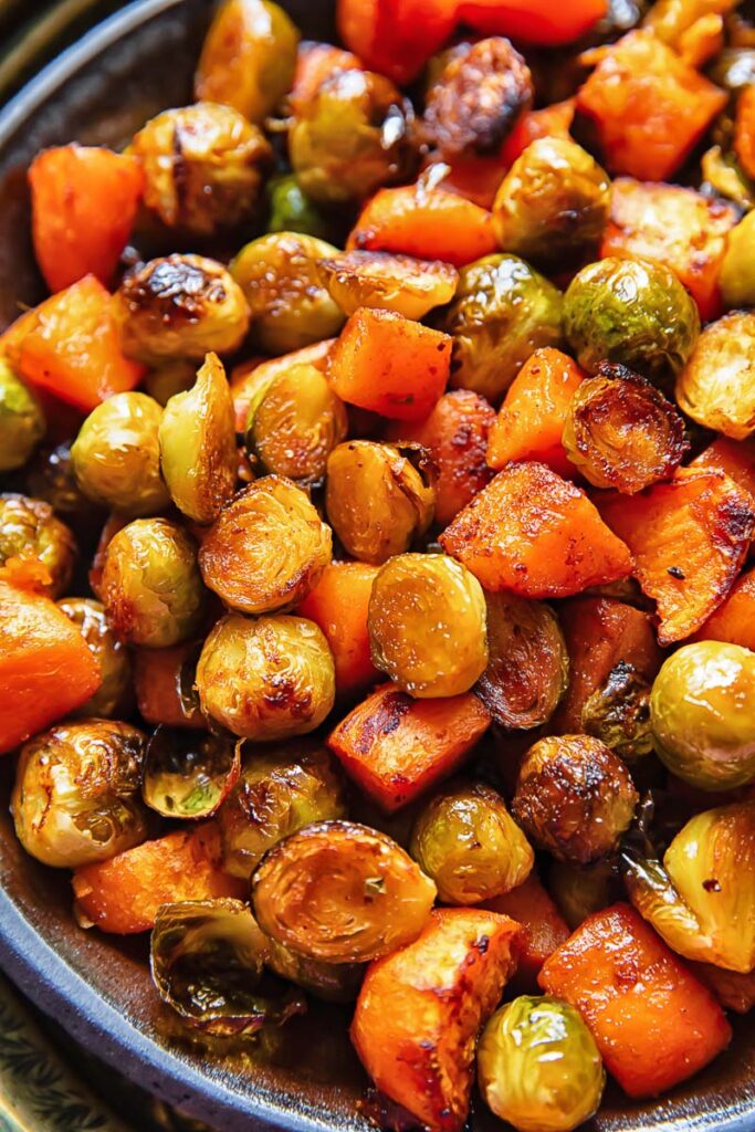 Close up of brussel sprouts and sweet potatoes in a large bowl