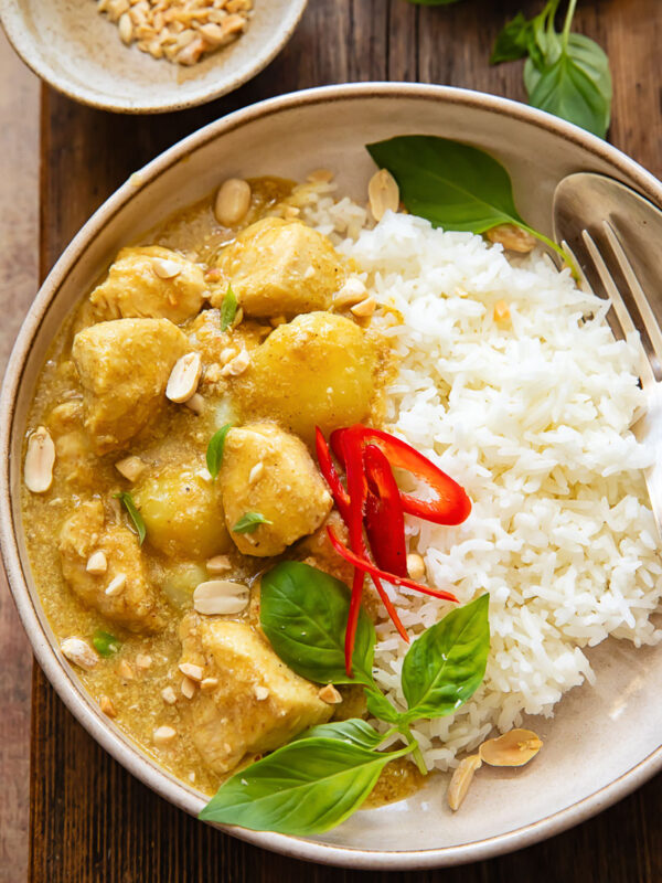 Top down shot of yellow chicken curry with rice on a plate