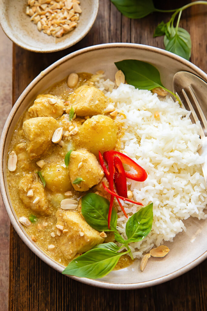 Top down shot of yellow chicken curry with rice on a plate