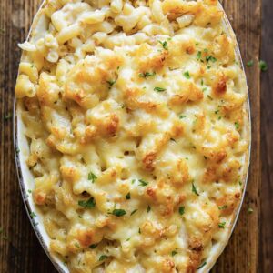 view of a baked pasta in an oval dish against a wood background