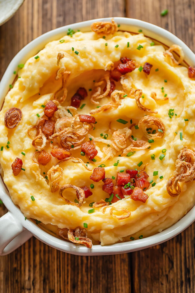 Close up of loaded mashed potatoes in a serving dish