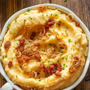 Cheesy mashed potatoes with crispy shallots in a bowl
