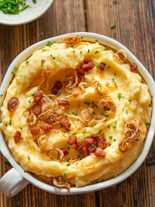 Cheesy mashed potatoes with crispy shallots in a bowl