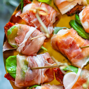close up of prosciutto caprese bites on a shiny pattern
