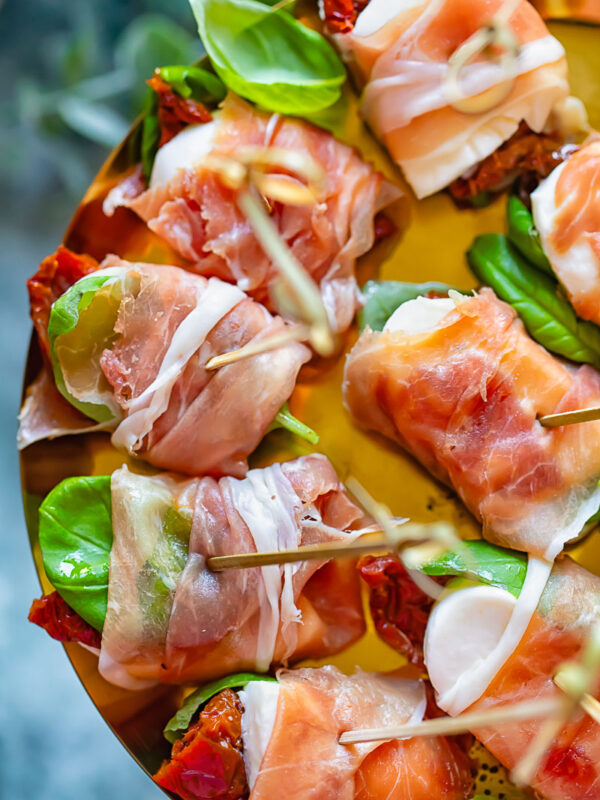 close up of prosciutto caprese bites on a shiny pattern