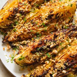 four cabbage wedges with chopped nuts and herbs