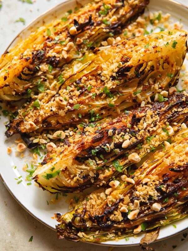 four cabbage wedges with chopped nuts and herbs