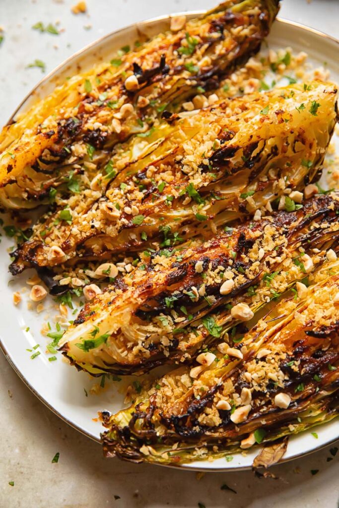 four cabbage wedges with chopped nuts and herbs