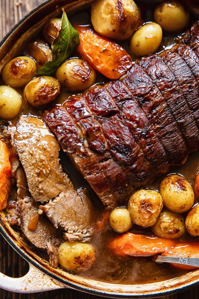 Close up of pot roast and veg in a large pot