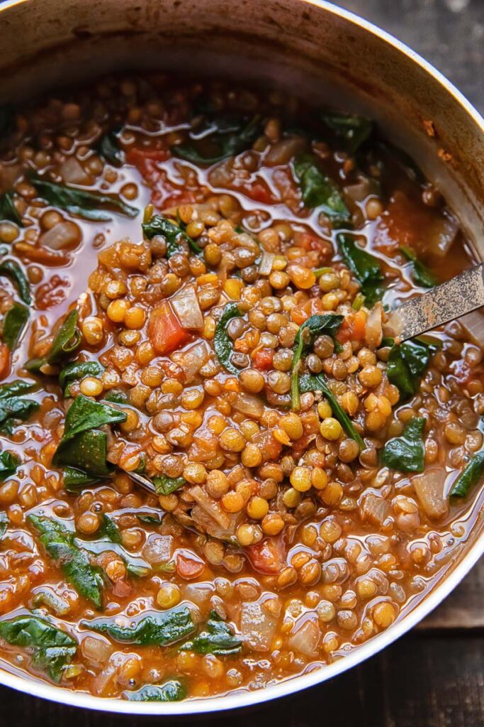 Lentil spinach soup in a pot with a ladle 