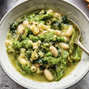 bowl of soup with heaped green vegetables mixed with white beans and macaroni
