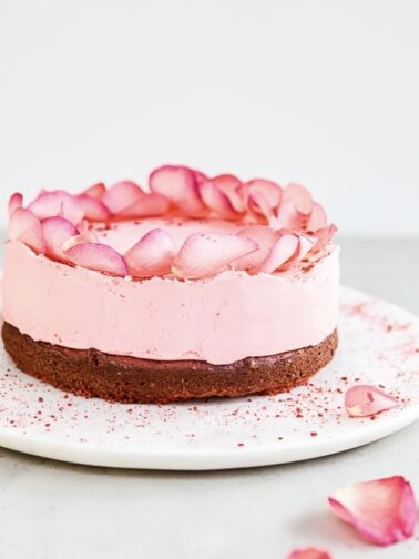 pink cake, decorated with flowers on a white plate
