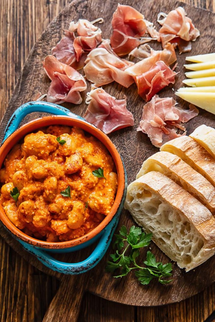 Top down shot of butter beans with sliced bread and cheese