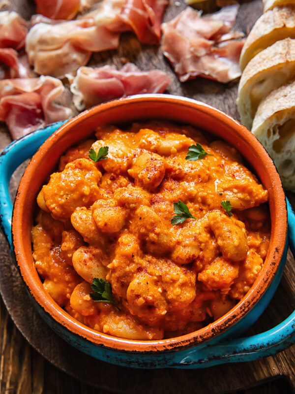 Close up of butter beans in Romesco sauce in a small serving dish