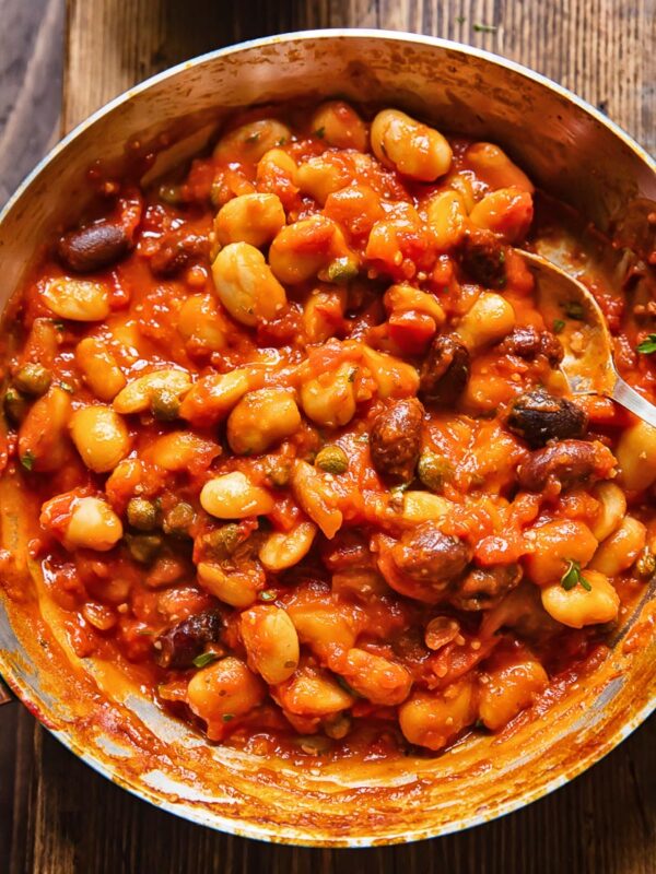 Top down shot of butter beans puttanesca in a pan