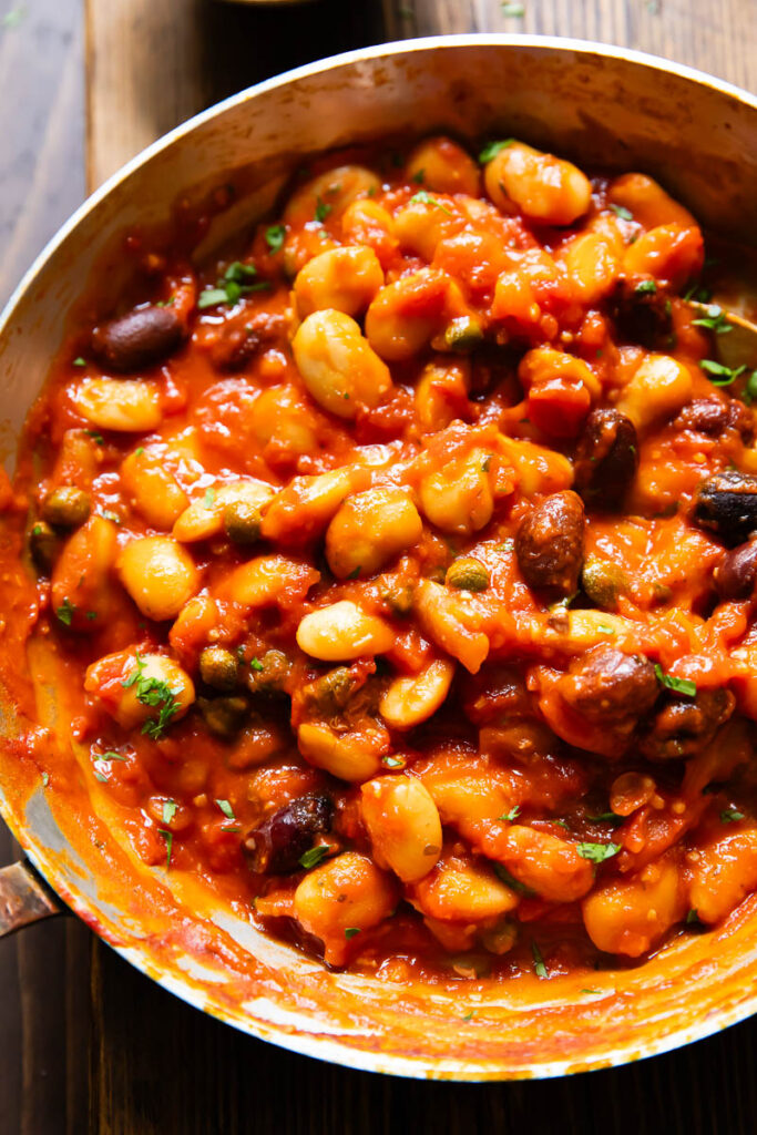 Close up of butter beans in puttanesca sauce