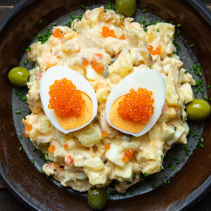 Top down shot of Spanish Russian Salad on a plate with a boiled egg