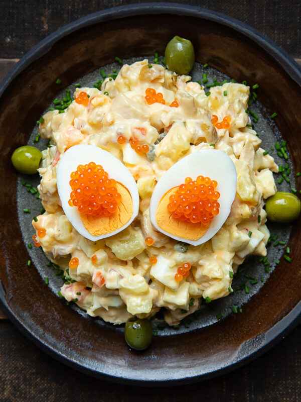 Top down shot of Spanish Russian Salad on a plate with a boiled egg