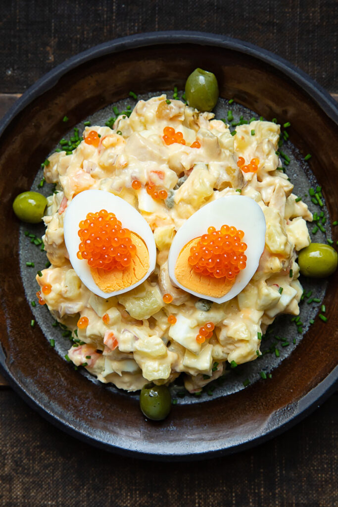 Top down shot of Spanish Russian Salad on a plate with a boiled egg