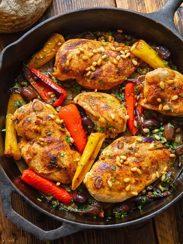 Top down shot of Mediterranean chicken in a pan with olives and peppers