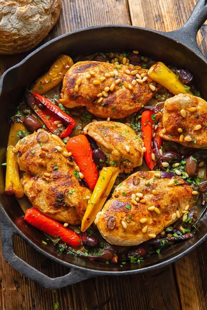 Top down shot of Mediterranean chicken in a pan with olives and peppers